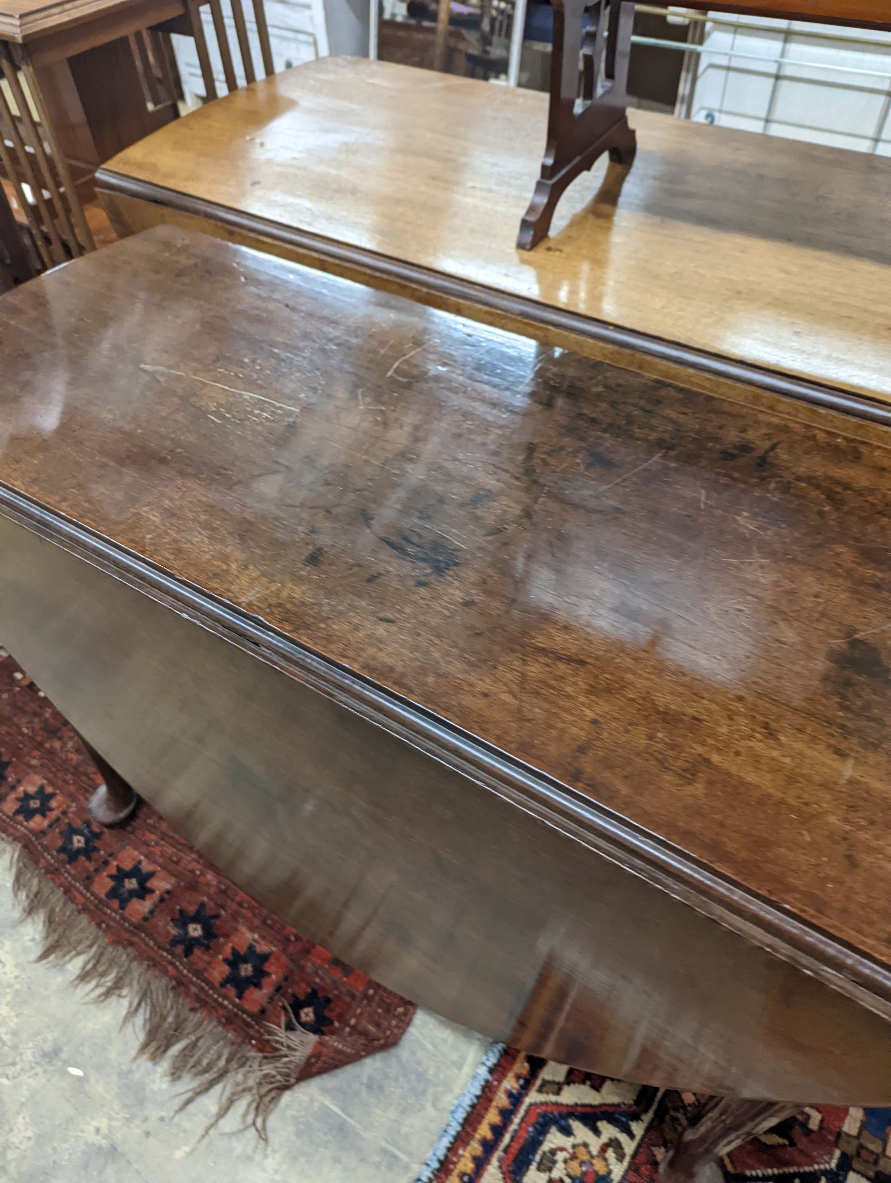 A George III oval mahogany drop leaf pad foot dining table, width 108cm, length 134cm extended, height 70cm